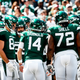 The Gotham Green-clad Jets offense huddles up.